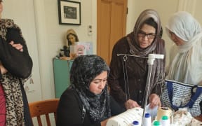 Auckland Afghani women sew reusable gift bags and reusable Christmas crackers. from left. Sara, Fatima, and Suraya attend a training session on June 20
