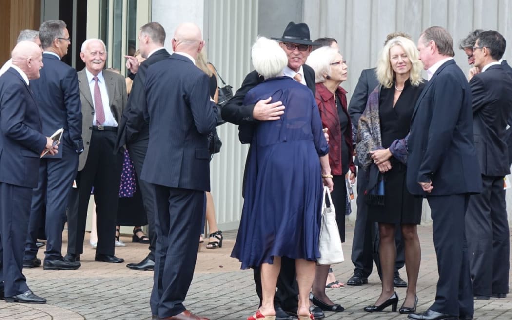 Jeff Crowe (centre) welcomes mourners to the funeral of his brother Martin.
