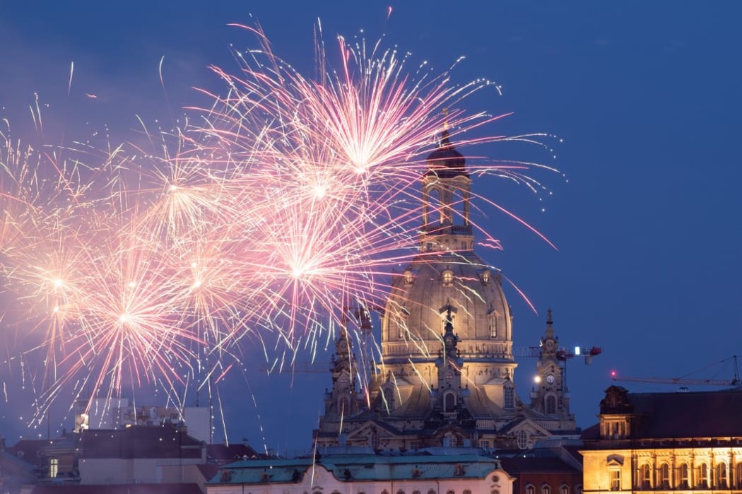 15 May 2020, Saxony, Dresden: Fireworks light up the evening sky in front of the Frauenkirche. The occasion is the nationwide opening of catering establishments during the Corona crisis. Photo: