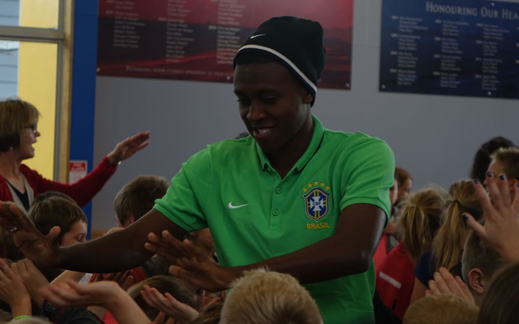 Brazilian player Jaja of the Flamengo club high fives children from Oakura Primary School.