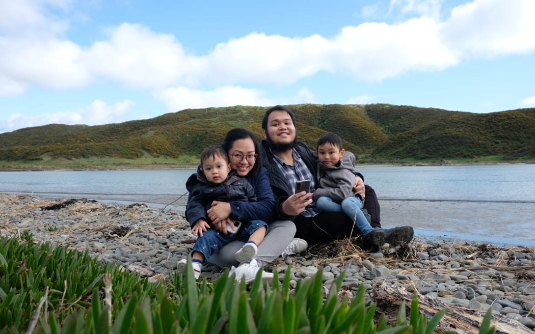 Neil and Abegail holding their children Sedric and Sebby.