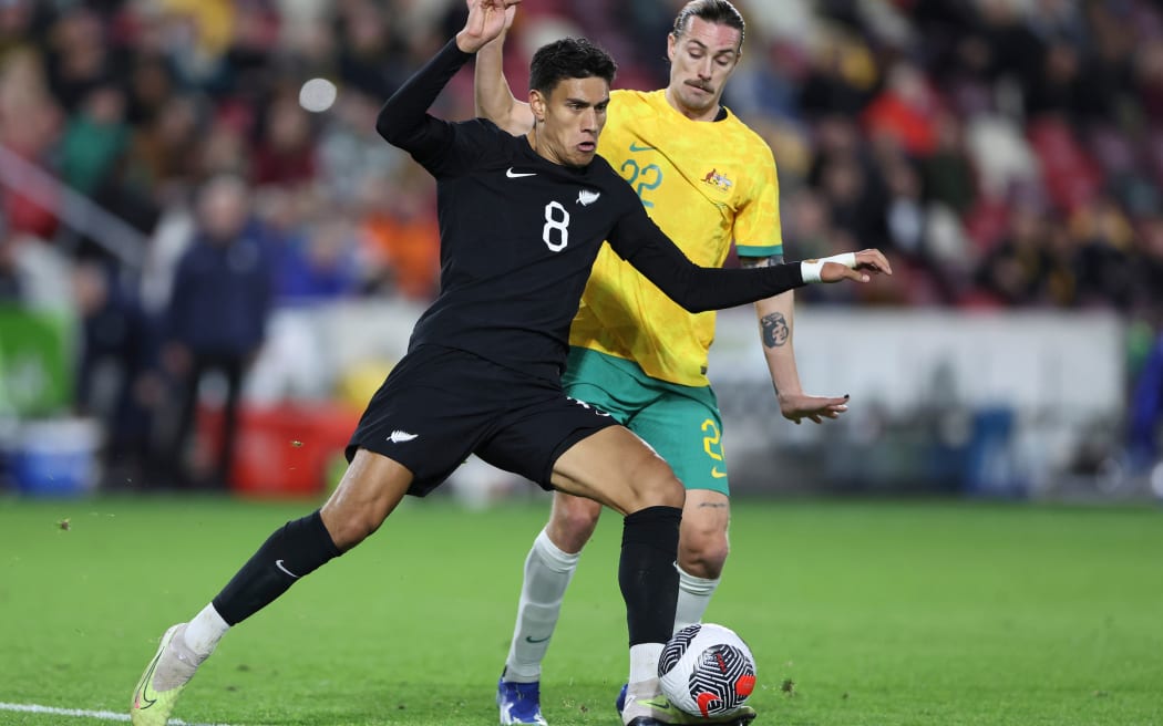 Marko Stamenic of New Zealand competes for the ball with Jackson Irvine of Australia.