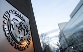 The seal for the International Monetary Fund is seen near the World Bank headquarters, right, in Washington, DC on 10 January, 2022.