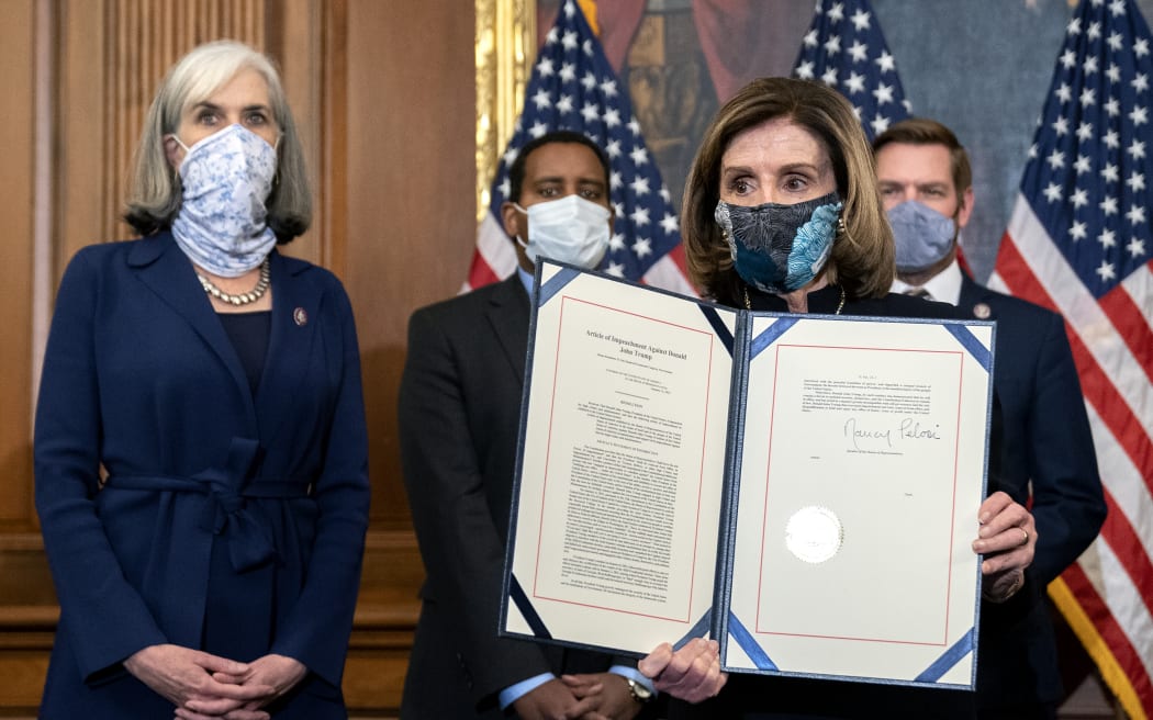 Speaker of the House Nancy Pelosi  displays a signed an article of impeachment against President Donald Trump at the Us Capitol.
