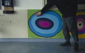 Lex with a painting of a geode that he is working on.