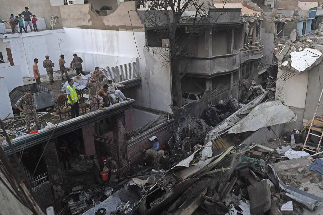 Security personnel search for victims in the wreckage of a Pakistan International Airlines aircraft after it crashed in a residential area in Karachi.