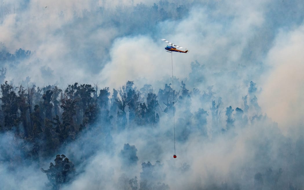 A helicopter dumping water on a fire in Victoria's East Gippsland region.