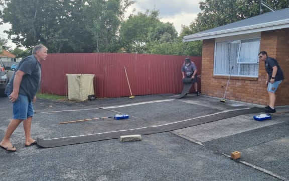 Councillors Max Brough, left, and Sam Bennett help NPDC chief executive Gareth Green repaint parking marking at the council-owned List St pensioner flats.