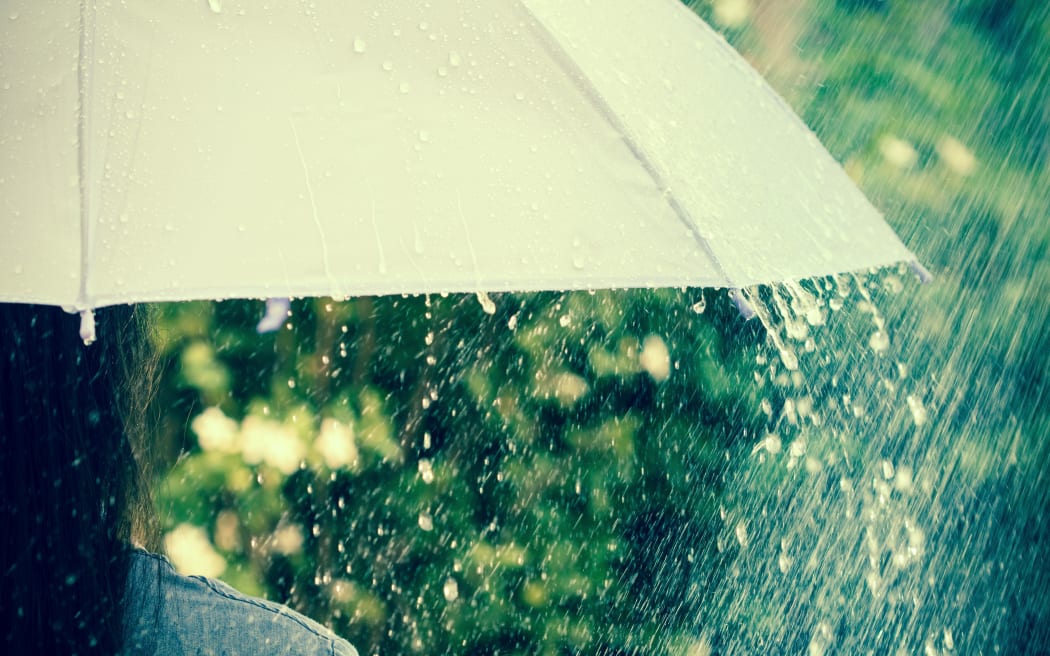 close up a part of the girl who hold on umbrella among Rain drops falling