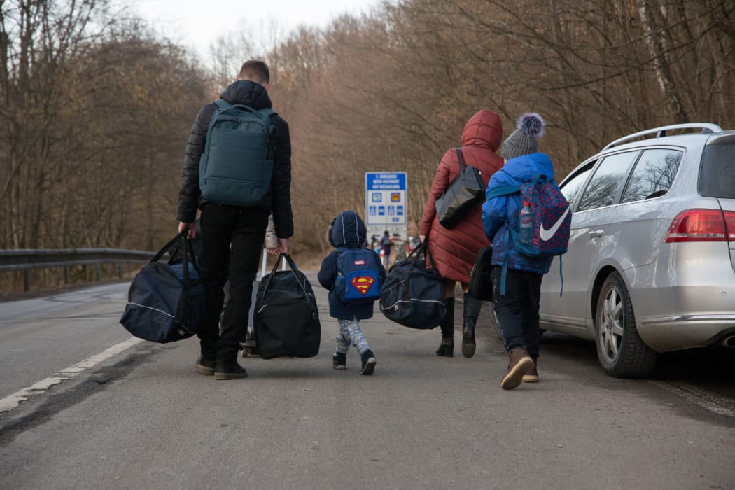 People carrying bags after crossing from Ukraine into Slovakia, 24 February 2022 .