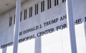 Workers finish installing President Donald Trump's name on the facade of the Kennedy Center in Washington, D.C., on December 19, 2025. (Photo by Andrew Thomas/NurPhoto) (Photo by Andrew Thomas / NurPhoto via AFP)