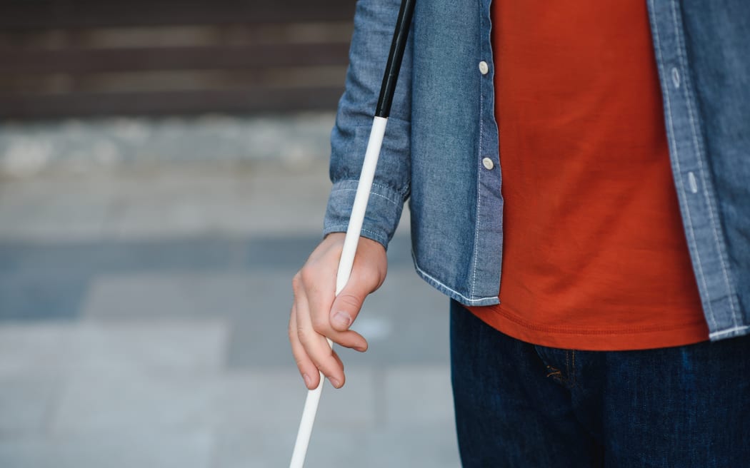 Close-up Of A Blind Man Standing With White Stick On Street.