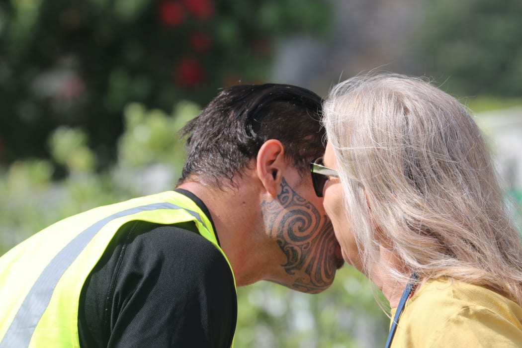 Local Māori warden greeting whānau outside Te Mānuka Tūtahi marae.
