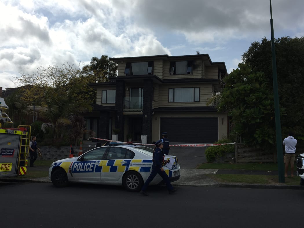 Police stand outside cordons where a fatal house fire occurred at Dawood Place, Manurewa.