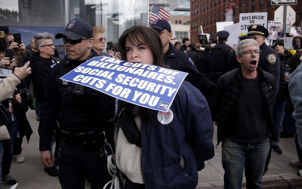 Demonstrators are arrested during a "TeslaTakedown" protest against Elon Musk outside of a Tesla dealership in New York, March 1, 2025. (Photo by Leonardo Munoz / AFP)