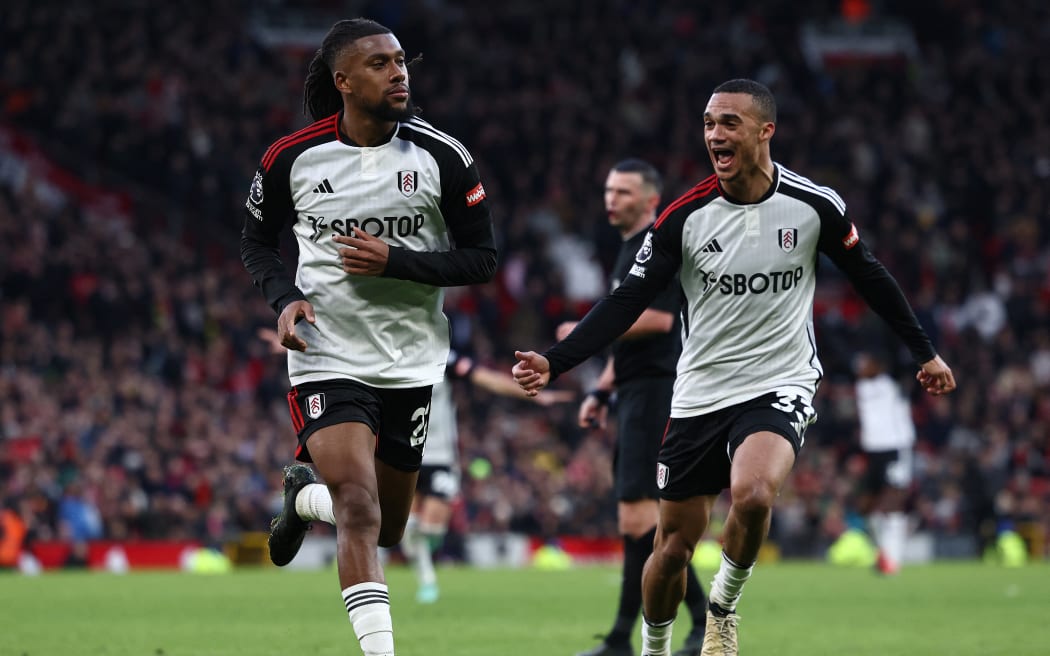 Fulham's Nigerian midfielder #22 Alex Iwobi (L) celebrates scoring the team's second goal during the English Premier League football match between Manchester United and Fulham at Old Trafford in Manchester, north west England, on February 24, 2024. (Photo by Darren Staples / AFP) / RESTRICTED TO EDITORIAL USE. No use with unauthorized audio, video, data, fixture lists, club/league logos or 'live' services. Online in-match use limited to 120 images. An additional 40 images may be used in extra time. No video emulation. Social media in-match use limited to 120 images. An additional 40 images may be used in extra time. No use in betting publications, games or single club/league/player publications. /