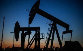 Oil pumpjacks operate at dusk Willow Springs Park in Long Beach, California on April 21, 2020.