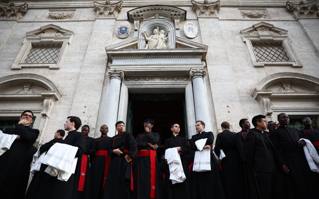 Members of the clergy wait outside the Church of Santa Maria del Carmelo in Traspontina in Rome ahead of late Pope Francis' funeral on April 26, 2025. Pope Francis, champion of the poor and the Church's first Latin American leader, will be honoured April 26 with a funeral attended by world leaders and tens of thousands of Catholic faithful. The Argentine pontiff, who died on April 21, 2025, aged 88, sought to create a more open-minded Church during his 12-year papacy, and many emotional tributes have been made -- with 250,000 people paying respects at his coffin in St Peter's Basilica. (Photo by HENRY NICHOLLS / AFP)