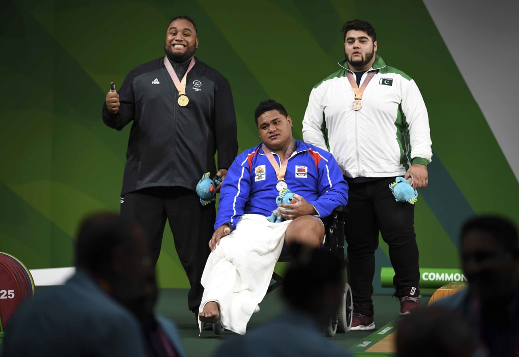 David Liti of New Zealand (L) celebrates winning the gold medal in the men's +105kg weightlifting final with silver medallist Lauititi Lui of Samoa (C) and bronze medallist Muhammad Nooh Dastgir Butt of Pakistan.