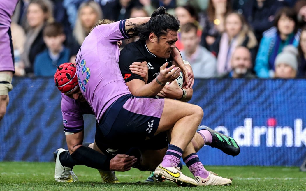 All Blacks winger Caleb Clarke is tackled by two Scotland defenders at Murrayfield.