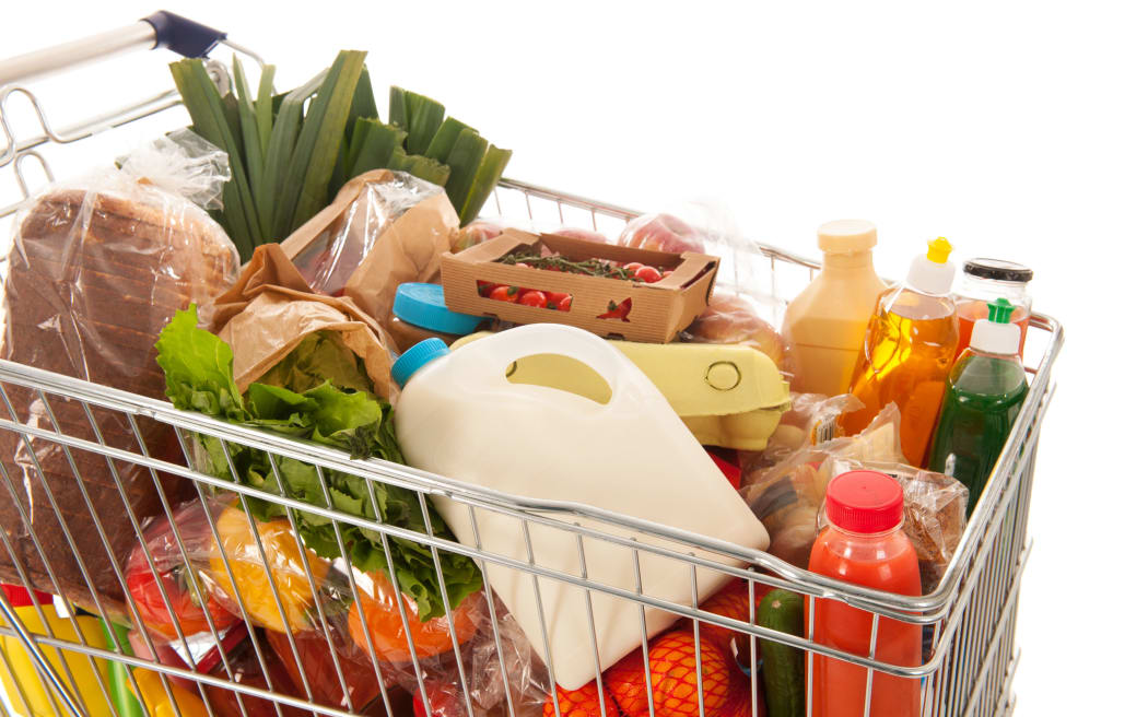 Shopping cart full with dairy grocery products isolated over white background