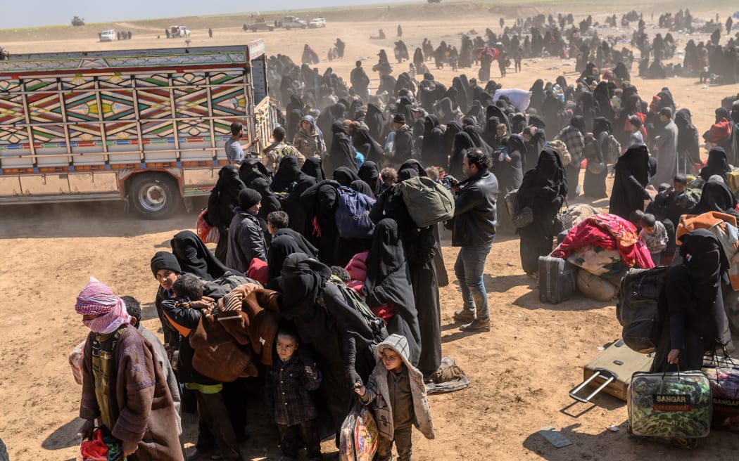 Women and children evacuated from the Islamic State (IS) group's embattled holdout of Baghouz arrive at a screening area held by the US-backed Kurdish-led Syrian Democratic Forces (SDF)