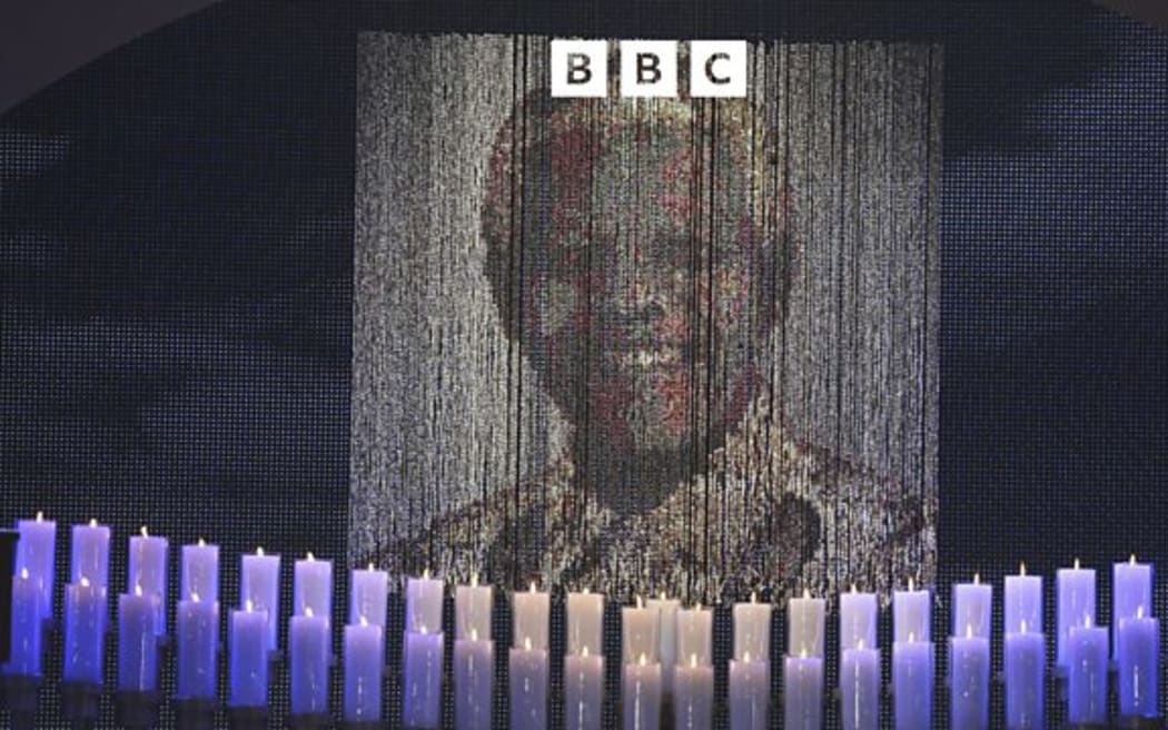 Candles are lit under a portrait of Nelson Mandela at his funeral service