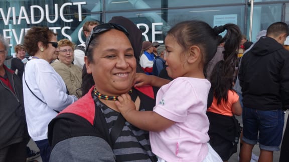 Pep Tuiasau and her daughter Marley-Jae wait in line for the Auckland City Mission Christmas lunch.