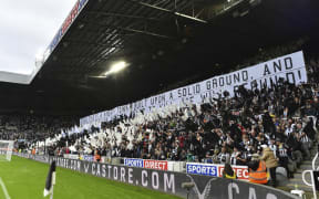 Newcastle United fans wave black and white flags and banners celebrating the club's recent take over by a Saudi-led consortium.