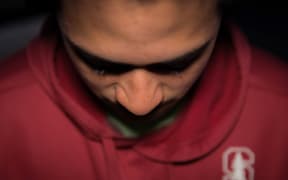 A teenage Māori boy looking unhappy
