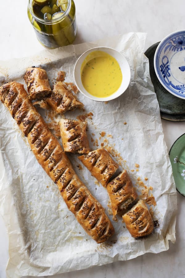 Two long sausage rolls on baking paper.