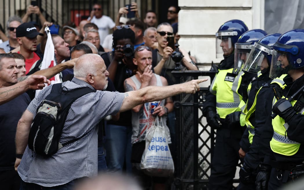 Protestors remonstrate with police officers during the 'Enough is Enough' demonstration on Whitehall, outside the entrance to 10 Downing Street in central London on July 31, 2024, held in reaction the Government's response to the fatal stabbings in Southport on July 29.