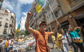 Protesters demonstrate to demand a tourism model respectful for  the islands environment and their residents, on the Canary Island of Tenerife, on April 20, 2024. Tens of thousands of demonstrators hit the streets across Spain's Canary Islands on Saturday to demand changes to the model of mass tourism they say is overwhelming the Atlantic archipelago. (Photo by DESIREE MARTIN / AFP)