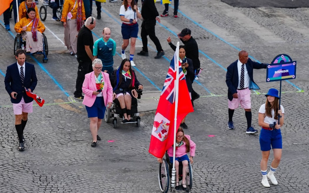 Los representantes de Bermudas llegan a la avenida de los Campos Elíseos durante la ceremonia inaugural de los Juegos Paralímpicos París 2024 el 28 de agosto de 2024 en París. (Foto de Dimitar Tilkoff/AFP)