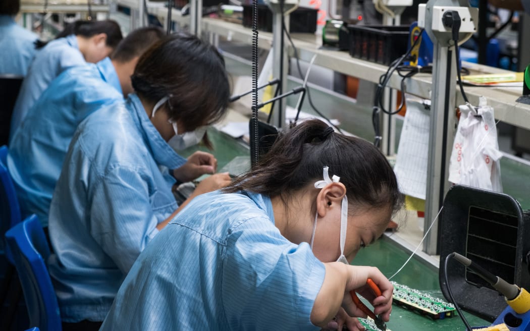 Chinese electronics factory workers in an industry manufacturing mssembly line