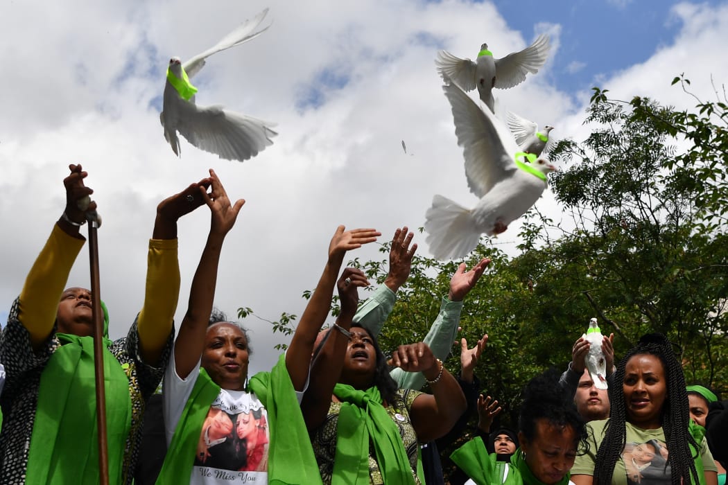 People release doves outside St Helen's church as part of commemorations on the anniversary of the Grenfell fire in West London.