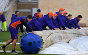 Groundstaff members roll up covers ahead of the 2019 Cricket World Cup group stage match between India and New Zealand at Trent Bridge in Nottingham.