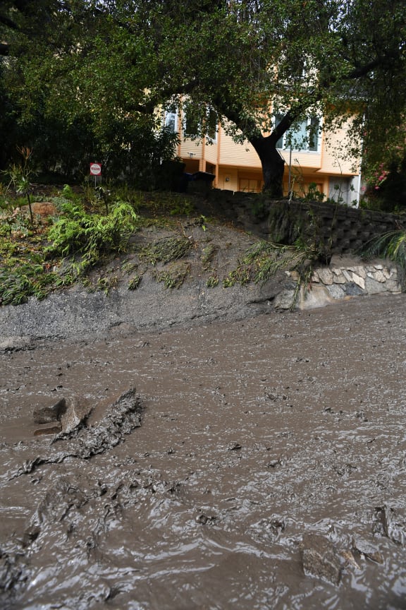 Mud fills a street after a rain-driven mudslide destroyed two cars and damaged property in a neighborhood under mandatory evacuation in Burbank, California.