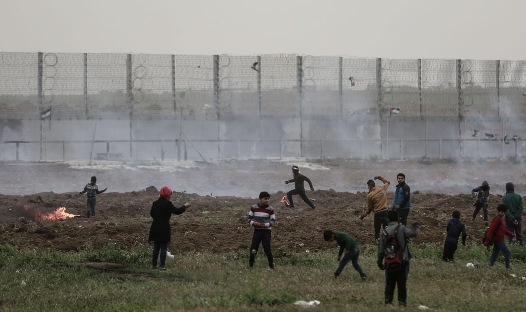 Palestinian protestors clash with Israeli forces near the Israel-Gaza border, on the first anniversary of the Great March of Return protests.