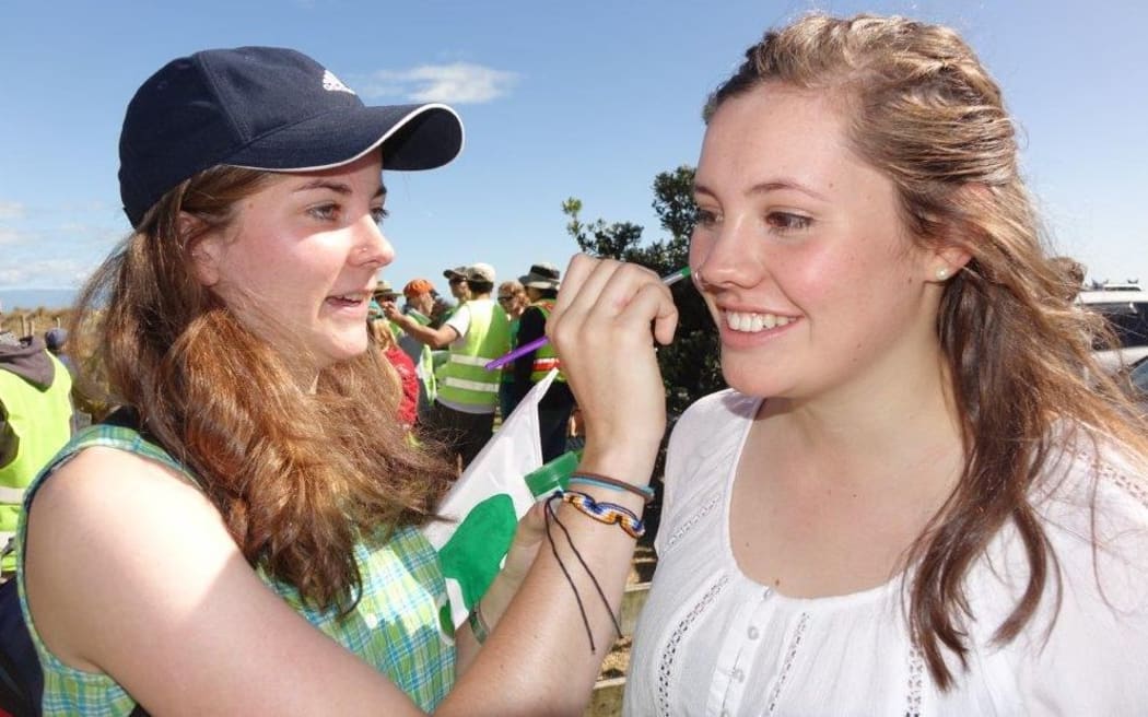 Nelson students Sophie Ross (left) and Maya De Larratea get into the spirit of the march with some face painting at Tahunanui Beach this morning.