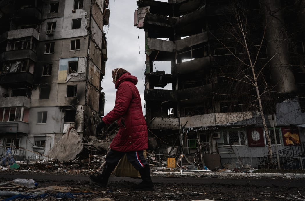 BORODIANKA, UKRAINE - APRIL 06: A woman walks past destroyed buildings after Ukrainian army regained control of Borodyanka, Ukraine on March 06, 2022.