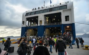 Residents of Santorini island and tourists bord the ferry in order to flee the island after the recent seismic activity and the fears of a volcanic awakening or a larger scale earthquake. Santorini, Greece on February 4, 2025. (Photo by STRINGER / SOOC / SOOC via AFP)