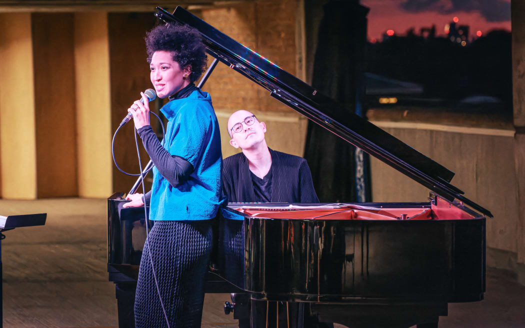An image of Julia Bullock standing at piano.