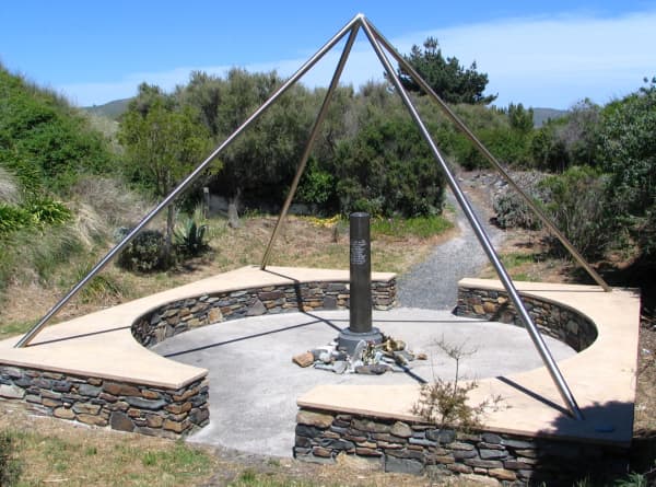 The Aramoana Massacre Memorial is a rectangular structure with a circular stone wall around it.
