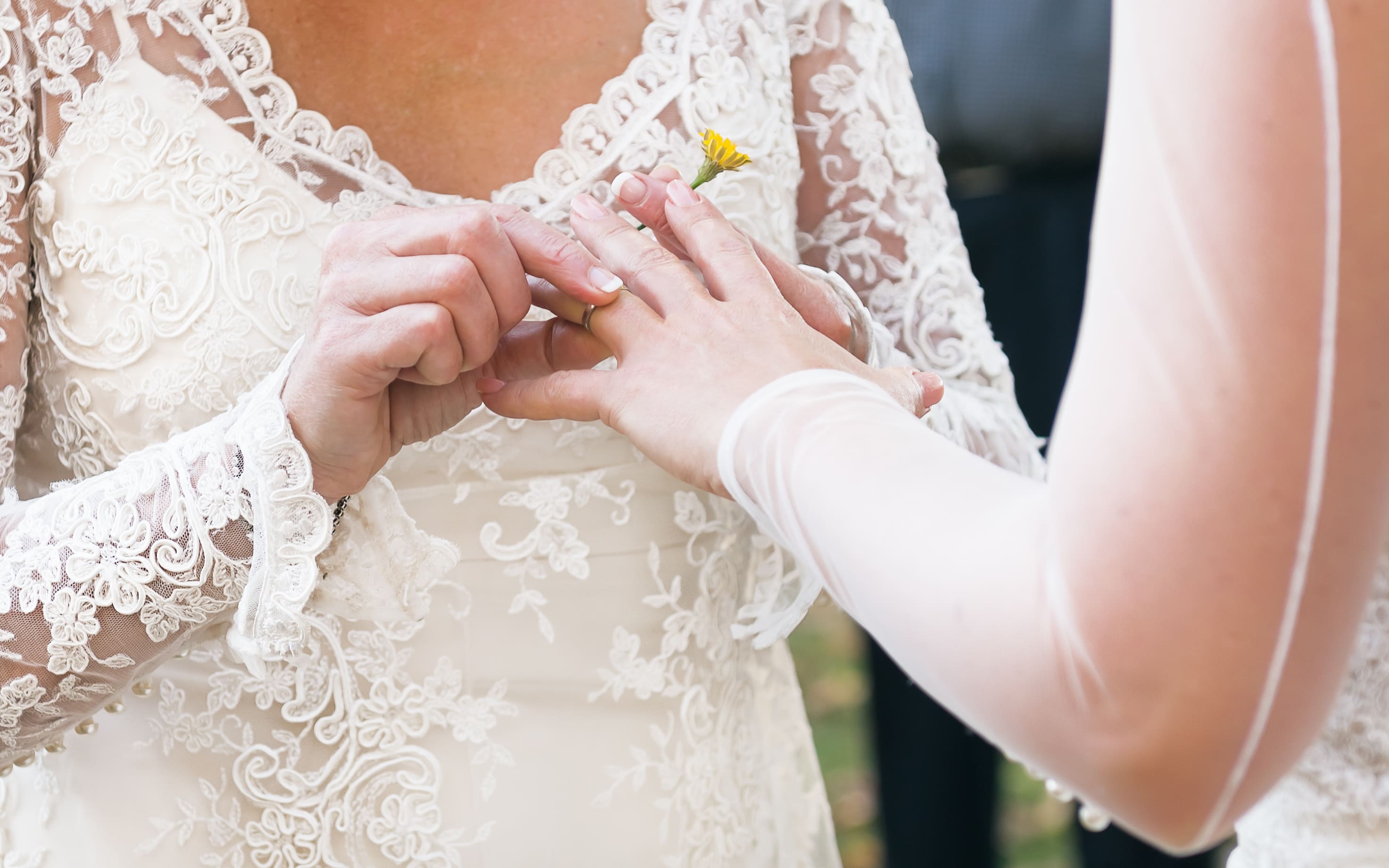 Same sex gay lesbian bride places ring on finger during wedding ceremony