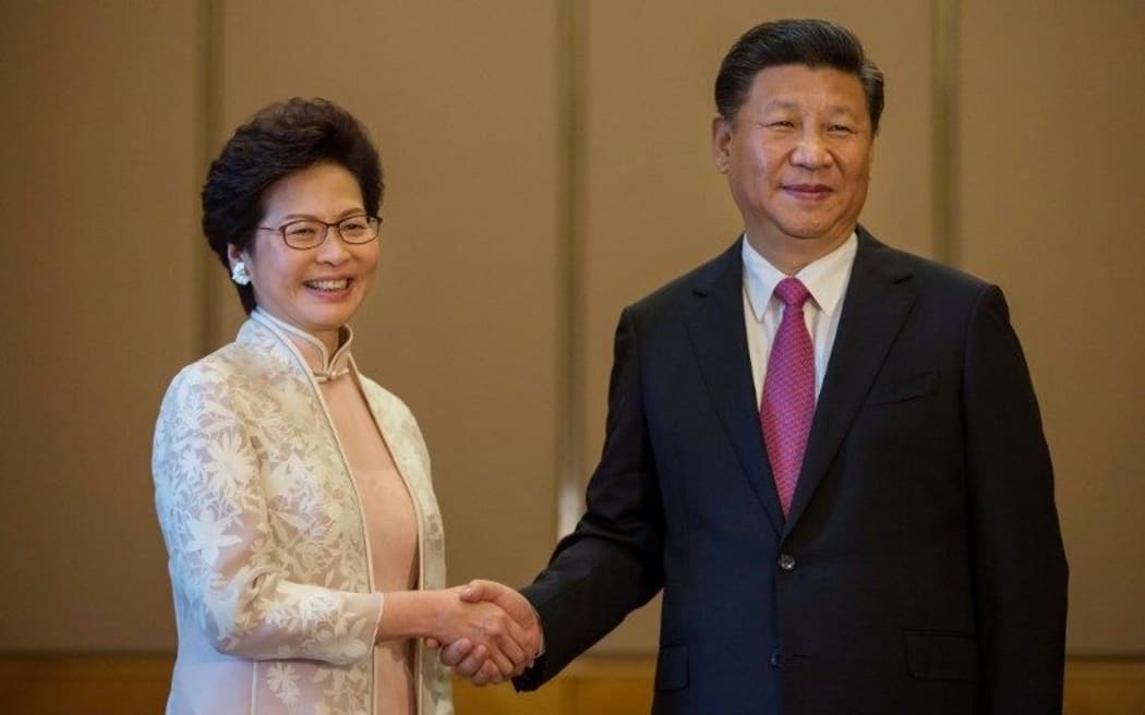 China's President Xi Jinping (R) shakes hands with Hong Kong's new Chief Executive Carrie Lam.