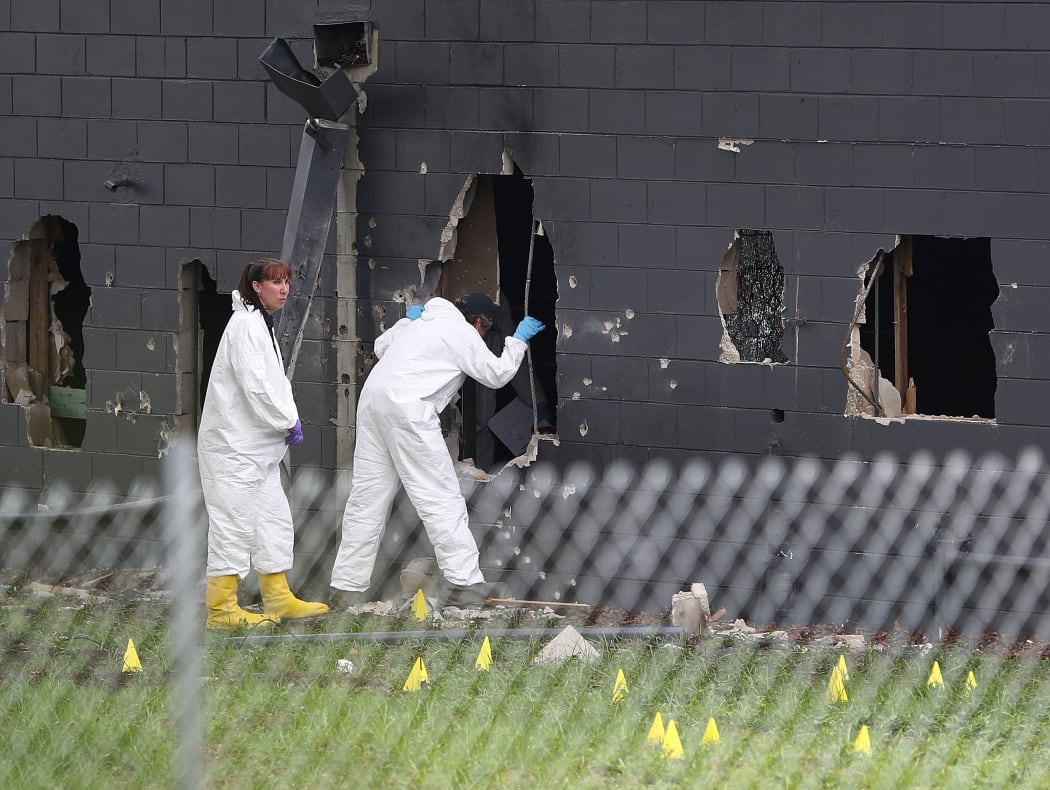 FBI agents investigate near the damaged rear wall of the Pulse Nightclub where Omar Mateen allegedly killed at least 50 people on June 12, 2016 in Orlando, Florida. The mass shooting killed at least 50 people and injuring 53 others in what is the deadliest mass shooting in the country's history.
