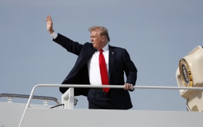 President Donald Trump waves while boarding Air Force One.