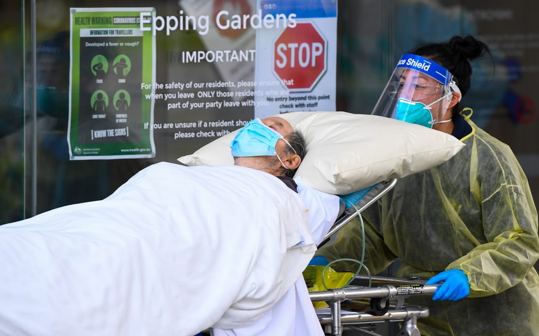 Ambulance officers transfer a resident from the Epping  Gardens aged care facility in the Melbourne suburb of Epping on 28 July 2020.