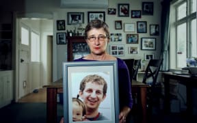 Kelly Savage's mother, Martha Savage holds a picture of her son. Kelly Savage died in in Japan after being restrained in a bed of a psychiatric hospital for 10 days.